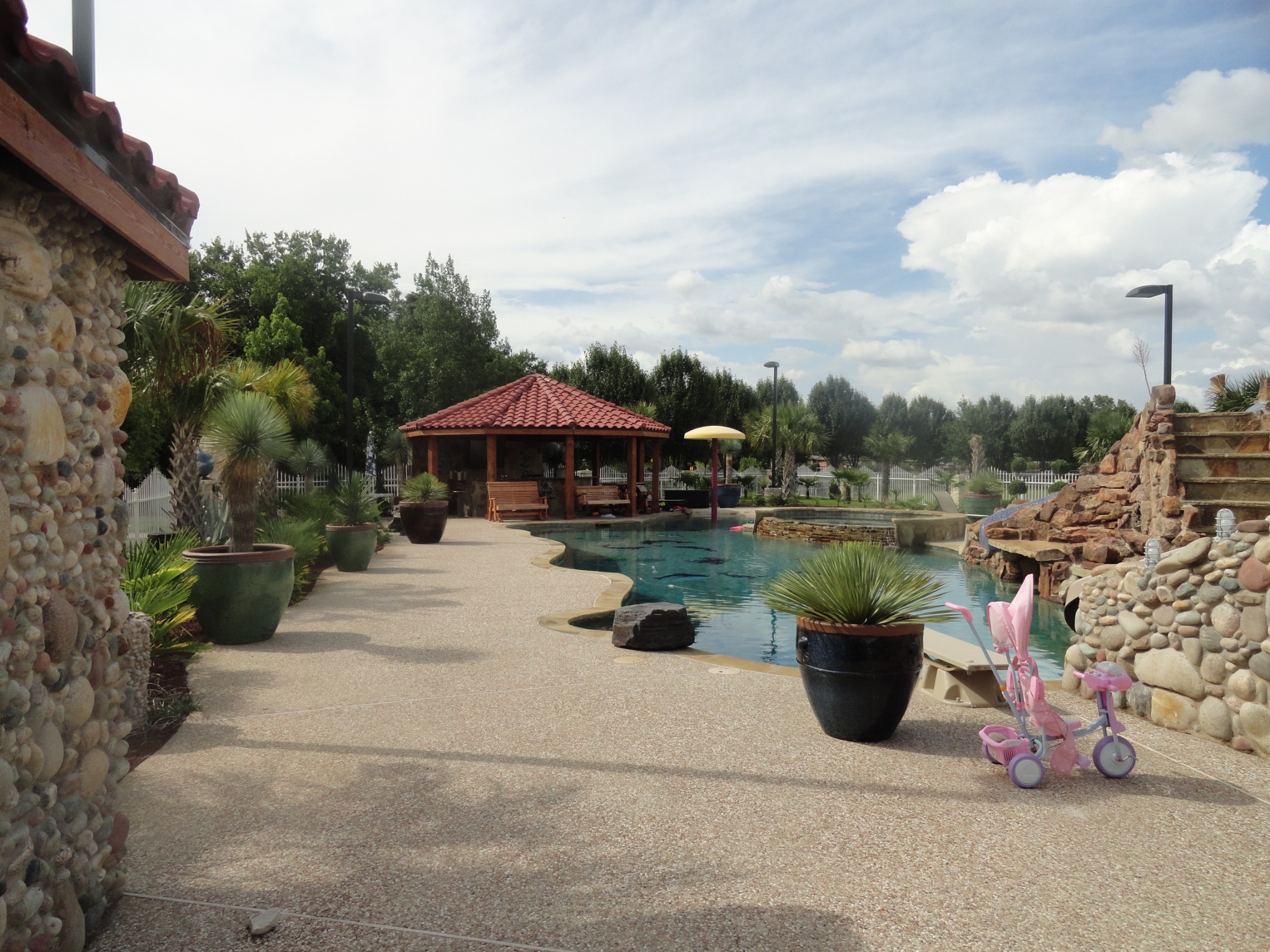 Custom pool, spa, cabana, and stone waterslide by King Pools