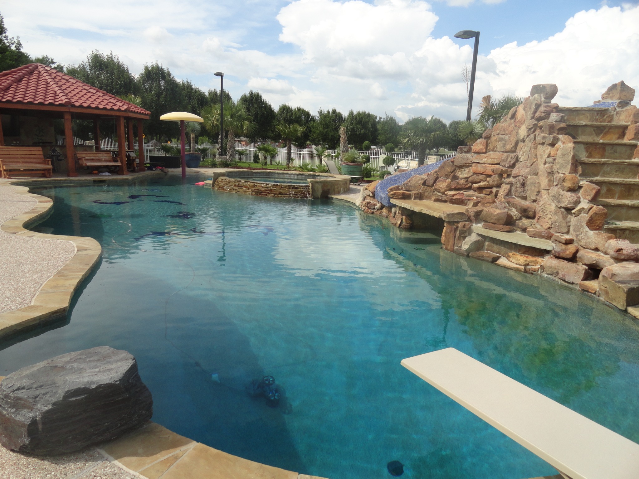 King Pools custom pool with waterfalls, stonework, spa, and outdoor living
