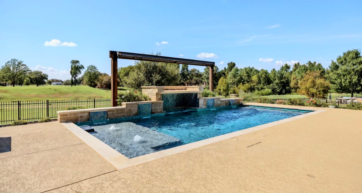 The cedar arch adds warmth and architectural presence at the far side of the pool.