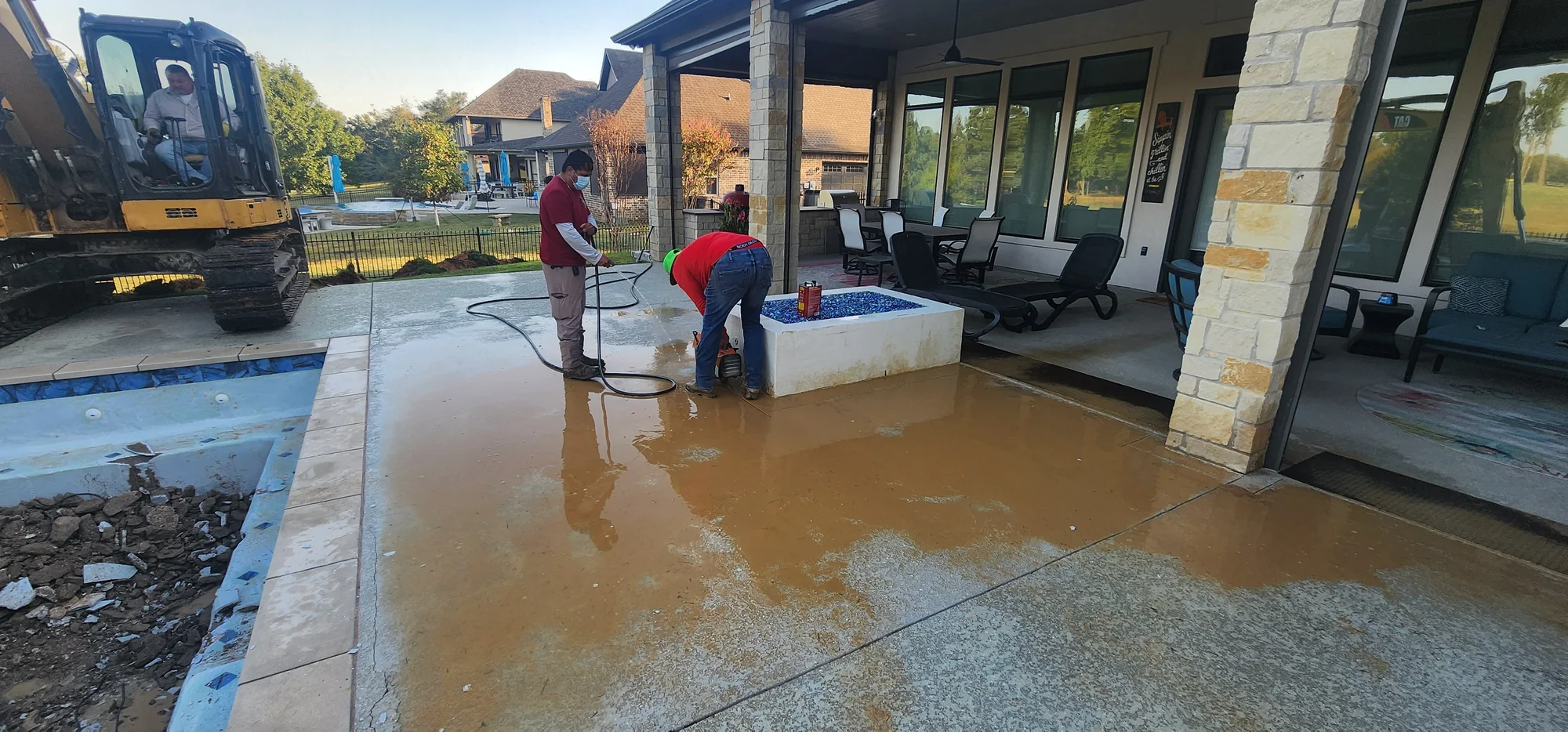 Pool demolition and deck work beside the fire feature