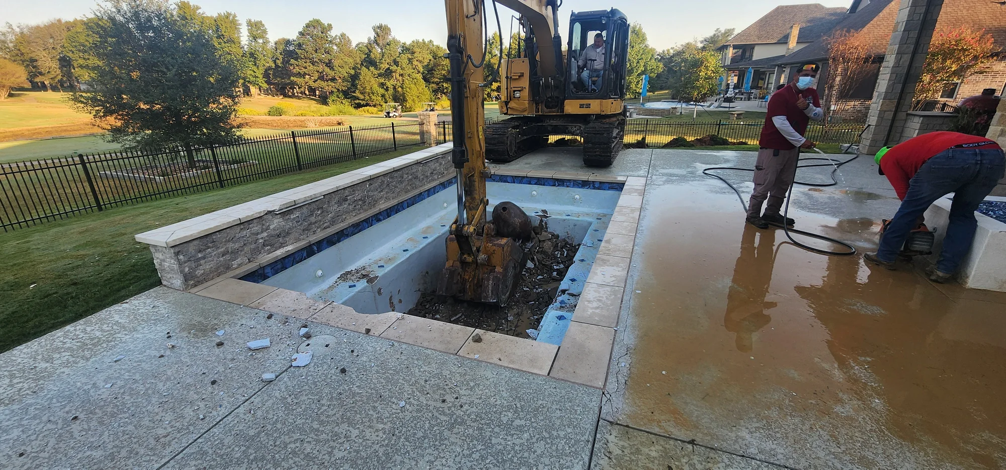 Original pool shell being removed by excavator