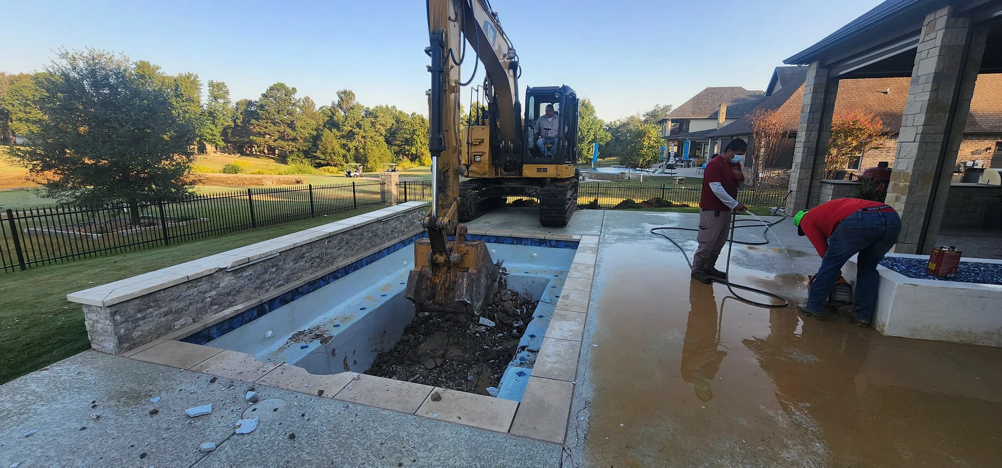 Excavator clearing the original pool and wet deck